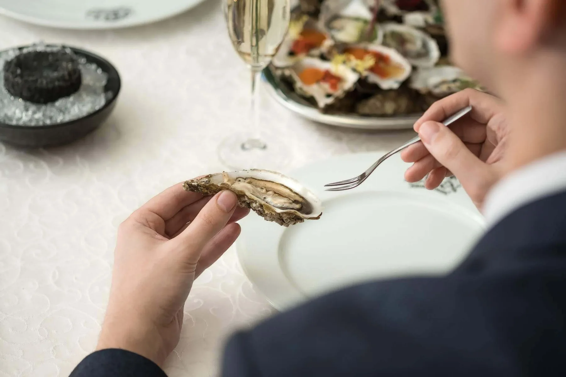 Guest eating an oyster at a set table